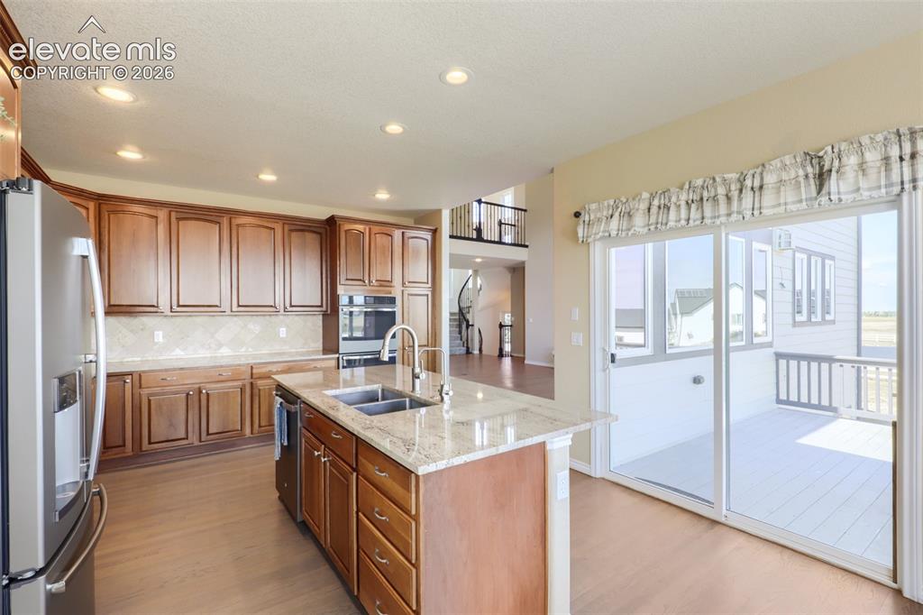 Image 14 of 37: Spacious, light-filled kitchen featuring solid wood cabinetry, granite coun