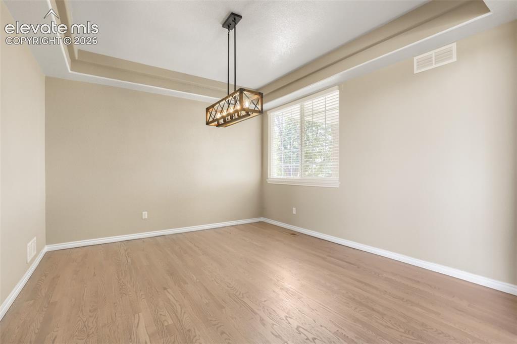 Image 16 of 37: Elegant formal dining room featuring a dramatic recessed tray ceiling, ligh