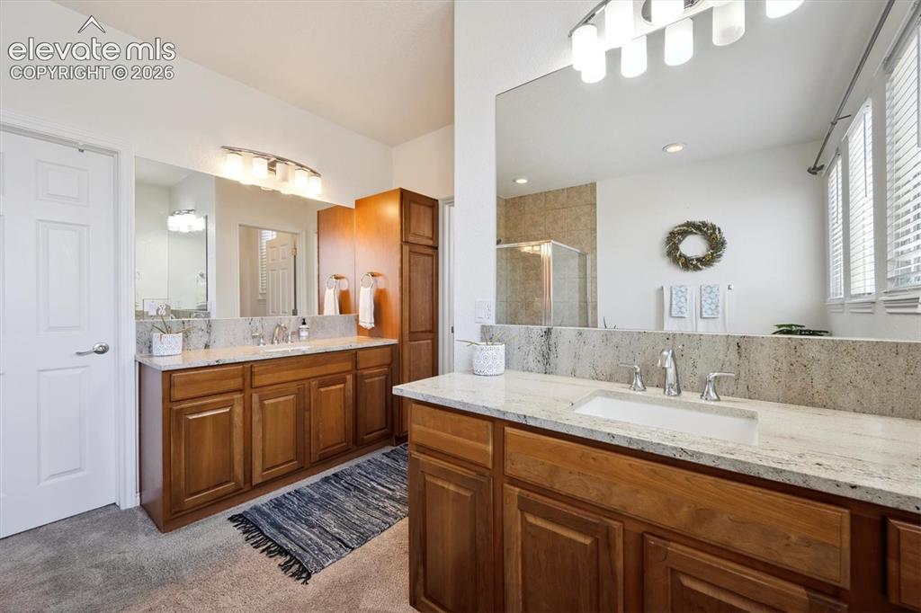 Image 19 of 46: Spacious 5 piece en-suite bathroom featuring dual wood-finish vanities with