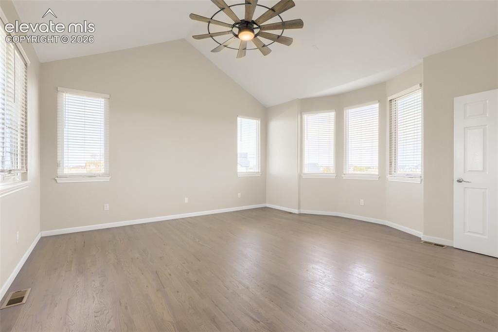Image 19 of 37: Spacious and serene main floor primary suite featuring dramatic vaulted cei