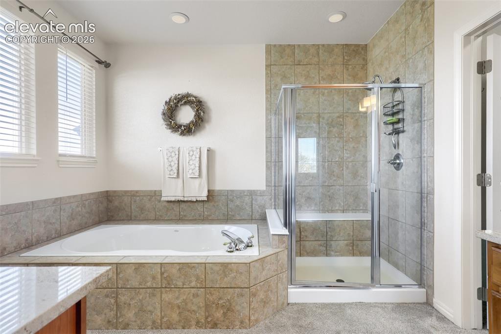 Image 22 of 37: Designed for relaxation, this 5-piece primary bathroom features a deep drop