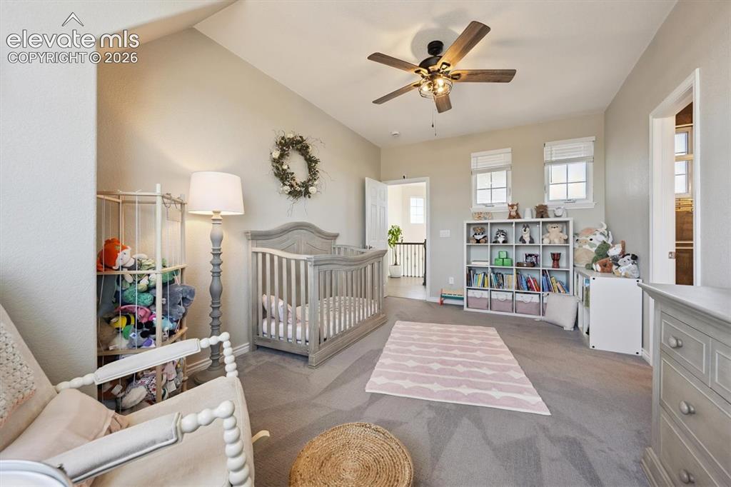 Image 23 of 46: Spacious room featuring vaulted ceilings, a ceiling fan with integrated lig