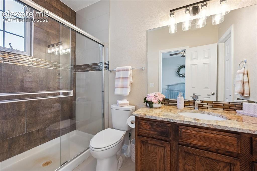 Image 24 of 46: Bathroom featuring a glass-enclosed shower with tile surround, a built-in w