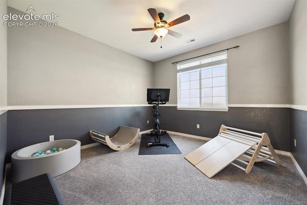 Image 25 of 46: Carpeted room featuring a ceiling fan with integrated lighting, a window wi