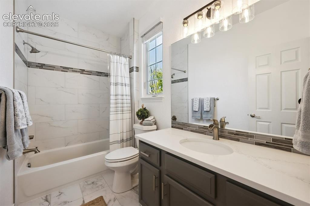 Image 26 of 46: Bathroom featuring a vanity with a white countertop and dark cabinetry, a l