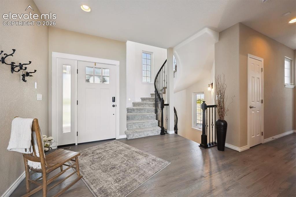 Image 3 of 46: Entryway featuring wood-finish flooring, a white front door with sidelight,