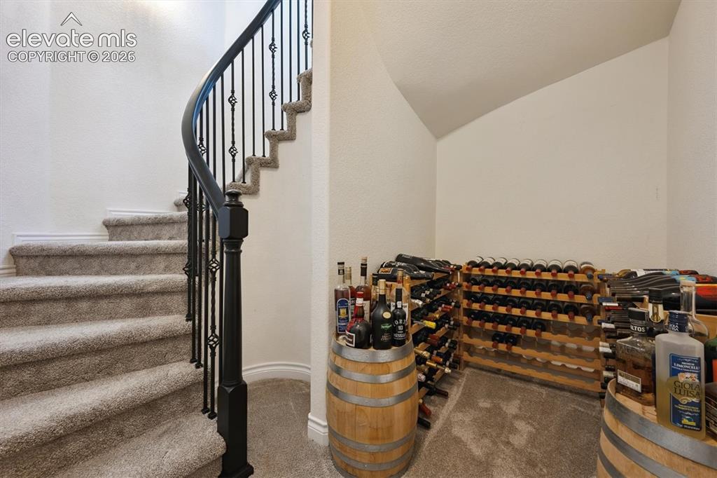 Image 31 of 46: Curved staircase with decorative wrought iron spindles and a dark-finished