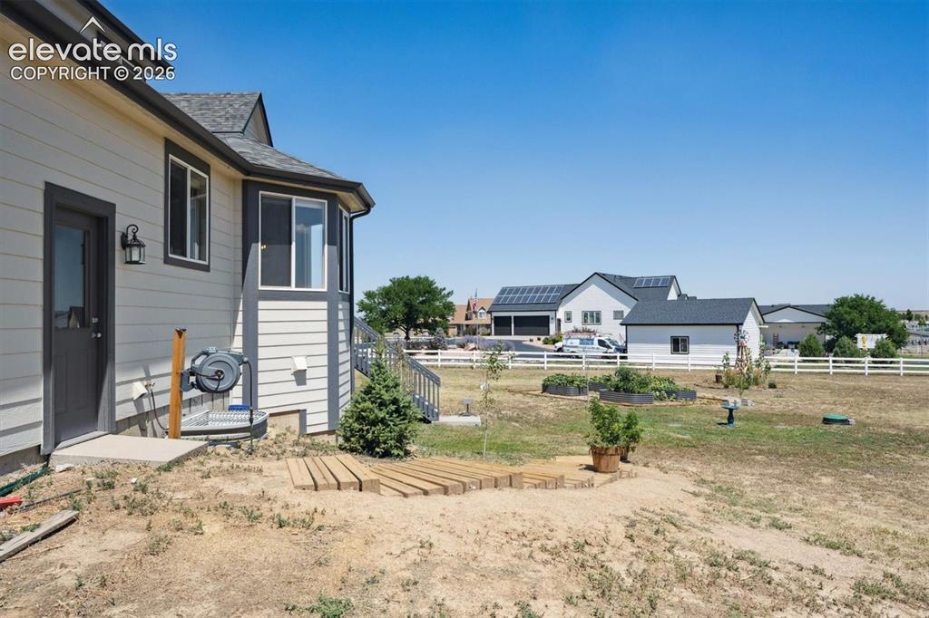 Image 35 of 46: Rear exterior showcasing light-colored horizontal siding, a bay window feat