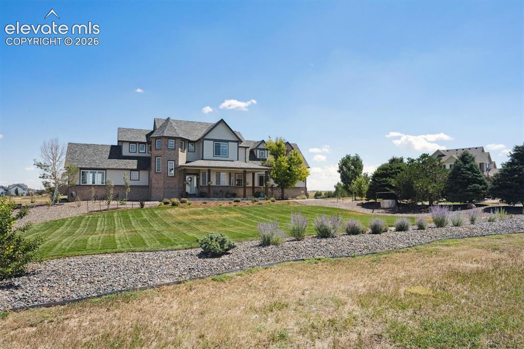 Image 38 of 46: Spacious property featuring a multi-story residence with brick and siding f