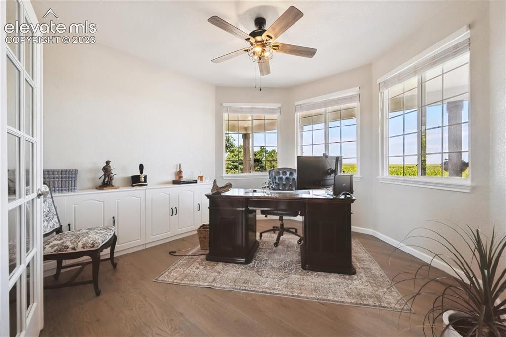 Image 4 of 46: Private room featuring French doors, wood-finish flooring, a ceiling fan wi