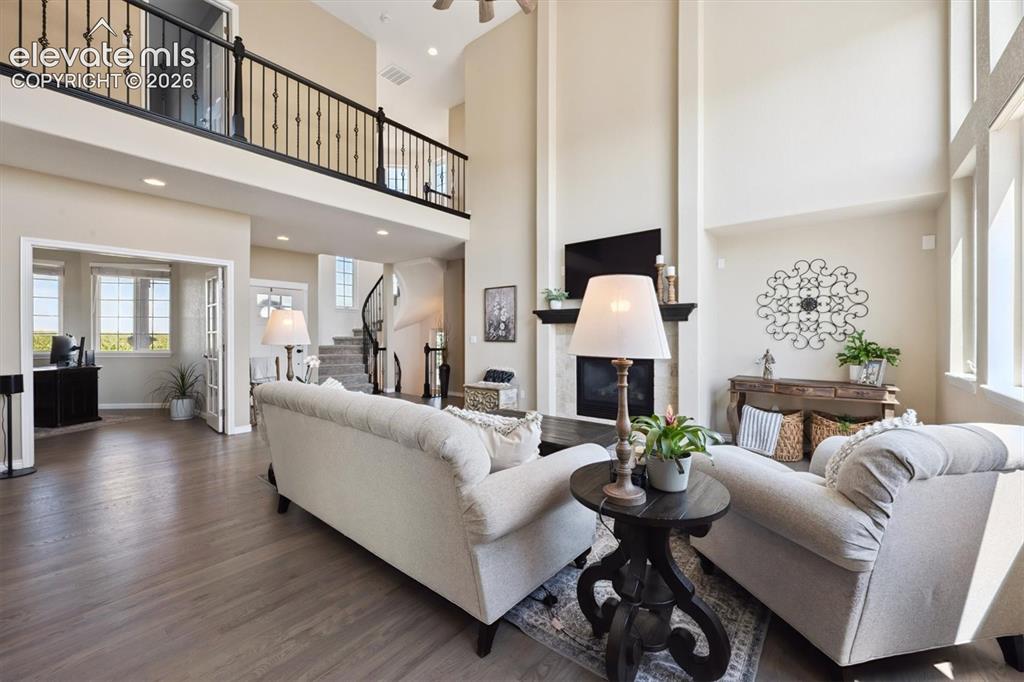 Image 6 of 46: Vaulted ceiling living area featuring a stone-clad fireplace with a dark wo