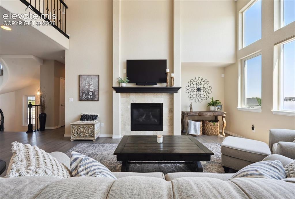 Image 8 of 46: Double-height living space featuring a fireplace with a stone-finish surrou