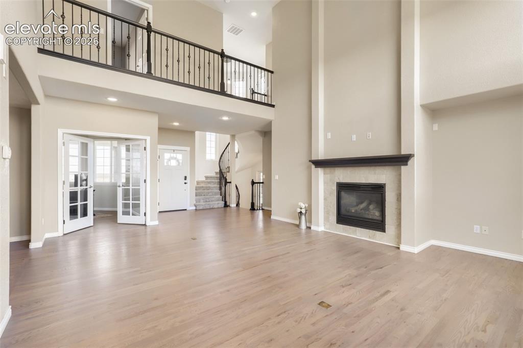Image 9 of 37: impressive two-story family room featuring a grand gas fireplace with tile