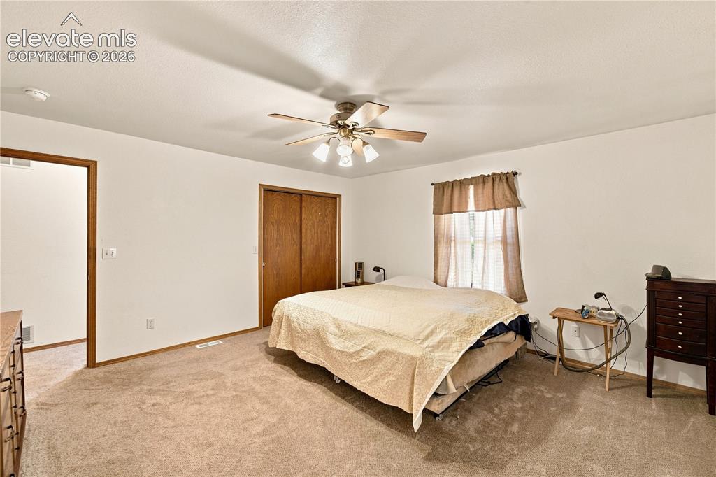 Image 11 of 37: Carpeted flooring, ceiling fan with integrated lighting, wood-finish bi-fol