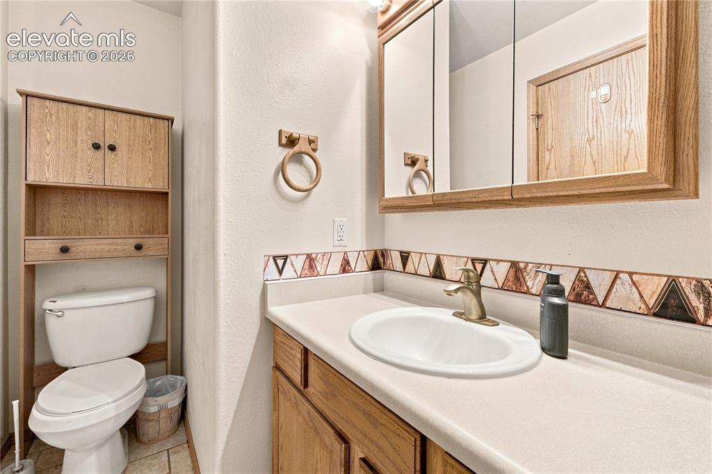 Image 13 of 37: Vanity with an integrated sink, framed mirrored medicine cabinet, wood-fini