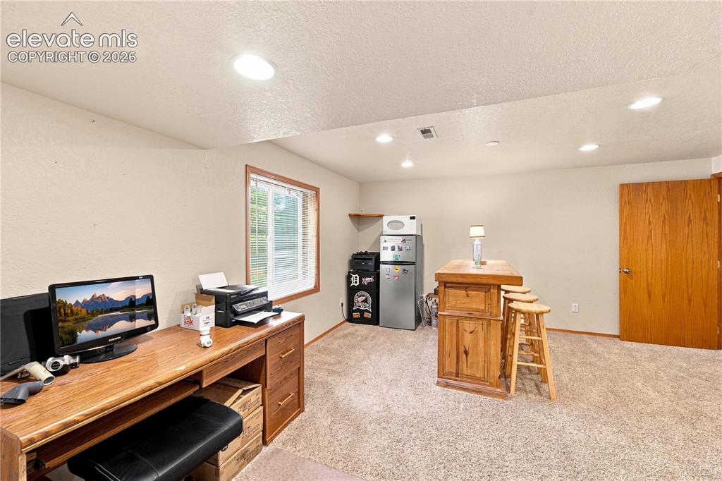 Image 17 of 37: Recessed lighting, wood-finish desk with drawers, natural light window, woo