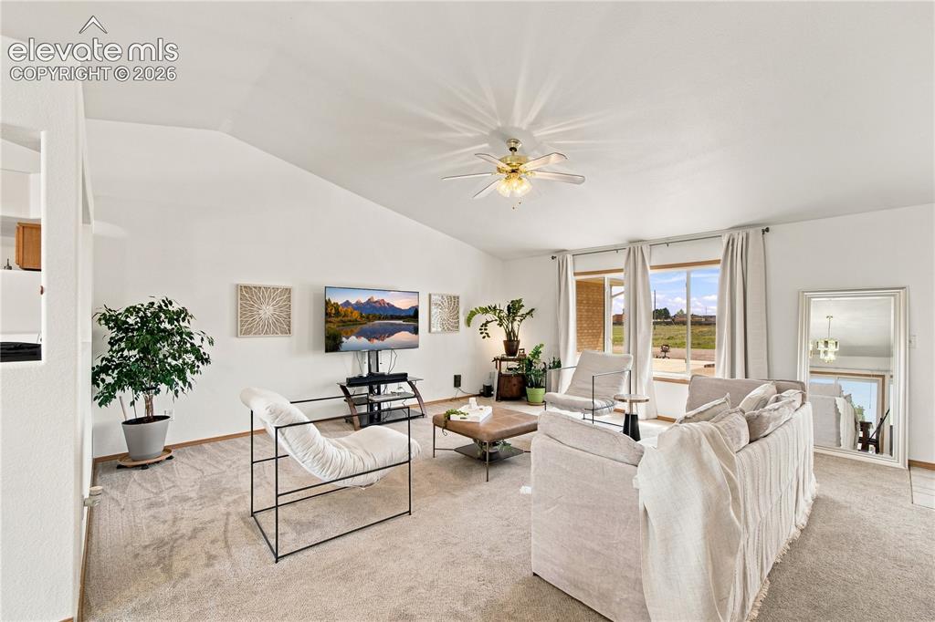 Image 3 of 37: Vaulted ceiling with a ceiling fan, dual windows, and carpet flooring