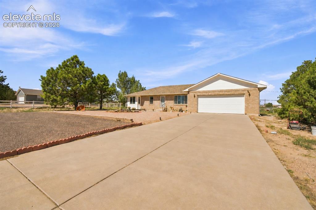 Image 33 of 37: Brick-clad exterior with an attached two-car garage, concrete driveway, and