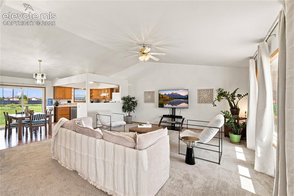 Image 4 of 37: Vaulted ceilings, a ceiling fan, and large windows with natural light