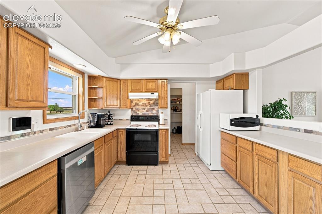 Image 9 of 37: Kitchen featuring wood cabinetry, light-toned countertops, tile flooring, s