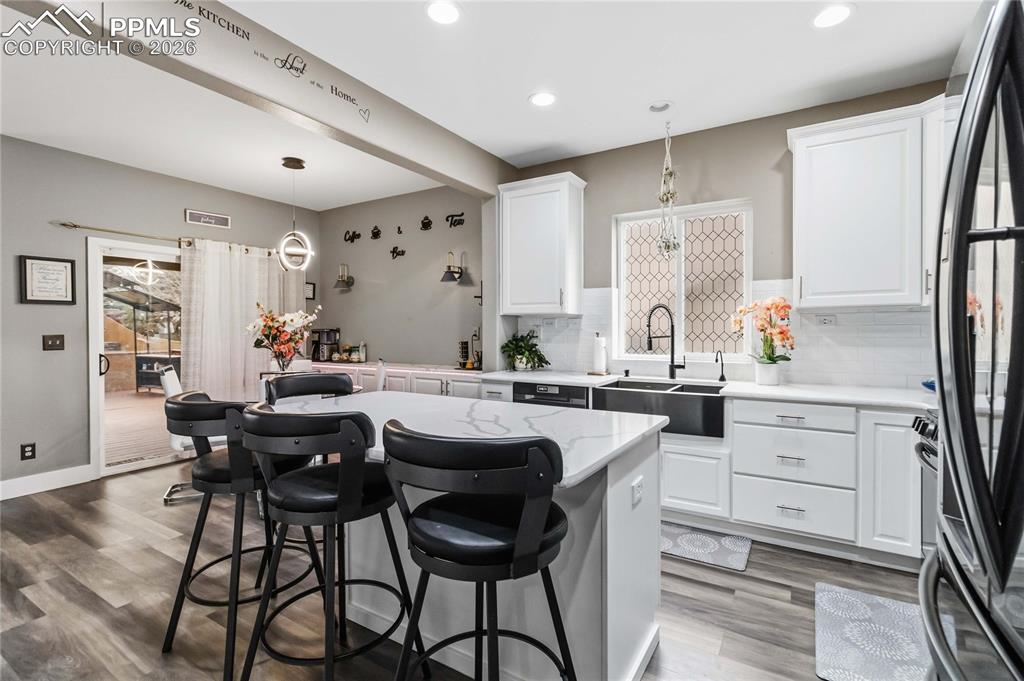Image 10 of 43: Open concept kitchen features white cabinetry, a large kitchen island with 