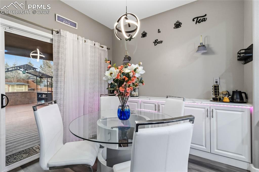 Image 12 of 43: Dining area with custom lighting and storage. Leads to outdoor deck. 