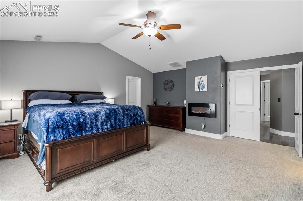 Image 21 of 43: This room features a vaulted ceiling, light-colored carpeting, a ceiling fa