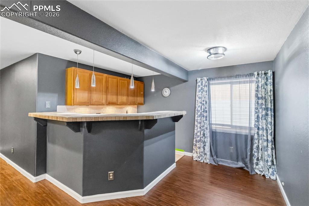 Image 33 of 43: Custom wet bar including sink and refrigerator with pendant lighting. 