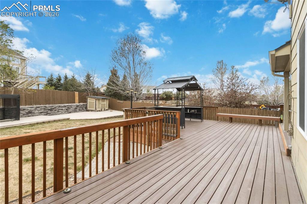 Image 39 of 43: Spacious outdoor deck with wood railings and a built-in bench. 