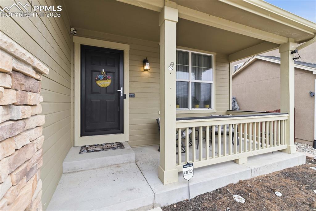 Image 4 of 43: Inviting front entry featuring a covered porch, an exterior light fixture, 