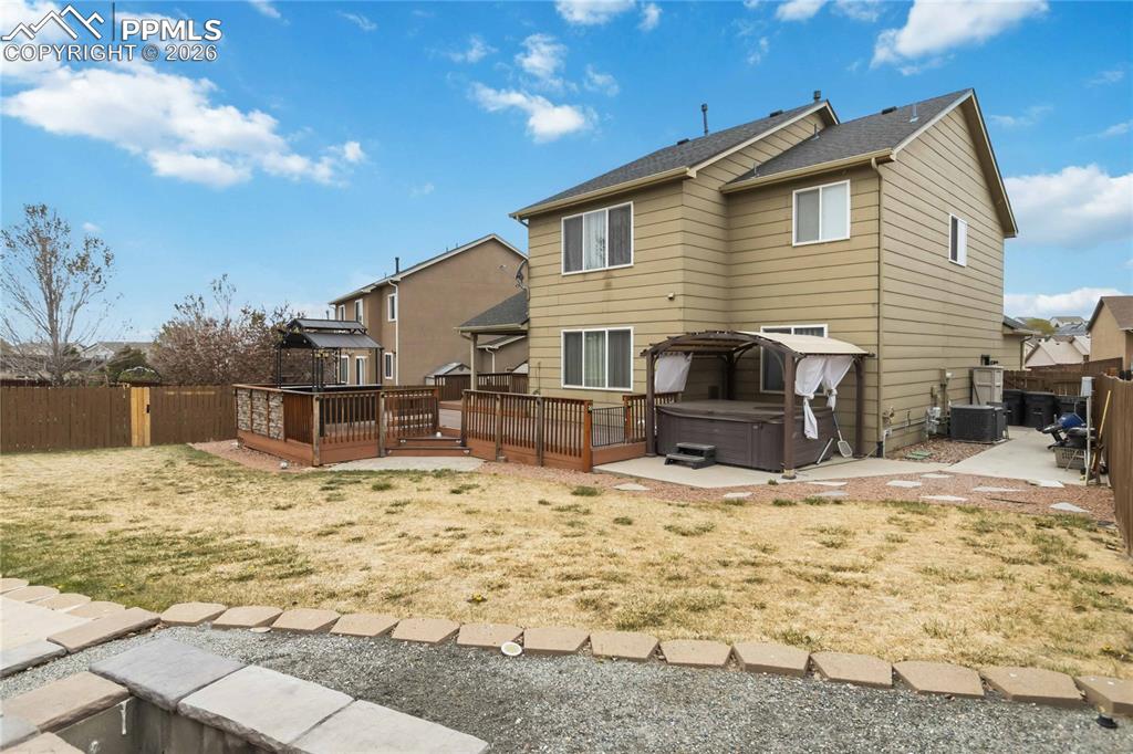 Image 42 of 43: Back view with hot tub and side yard access. 