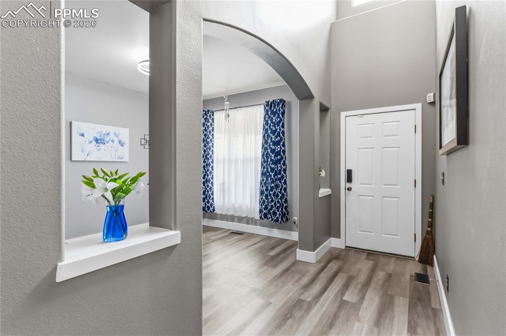 Image 5 of 43: Entryway featuring lots of light, LVP flooring and a room that could be an 