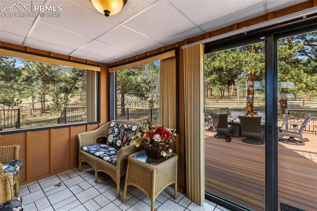 Image 16 of 50: beautiful sunroom area with ceramic tile flooring - steps out onto the mass