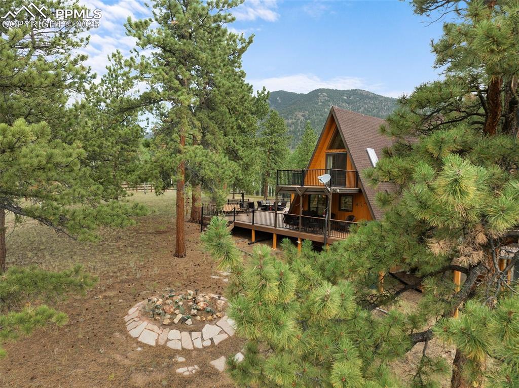 Image 3 of 50: Side view of main home showing firepit and seating
