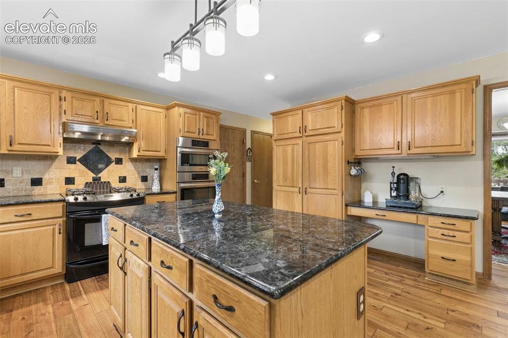 Image 15 of 50: Granite Countertops, Island, & Desk/Coffee Station Area