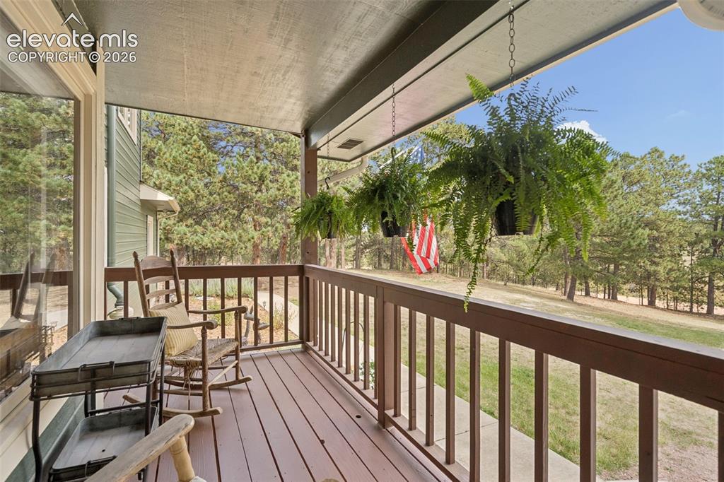 Image 6 of 50: Covered Front Porch Overlooking Yard & Open Space