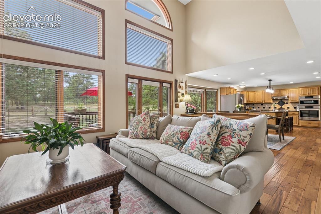 Image 8 of 50: Lots of Natural Light & Beautiful Forest View From Soaring Windows in the L