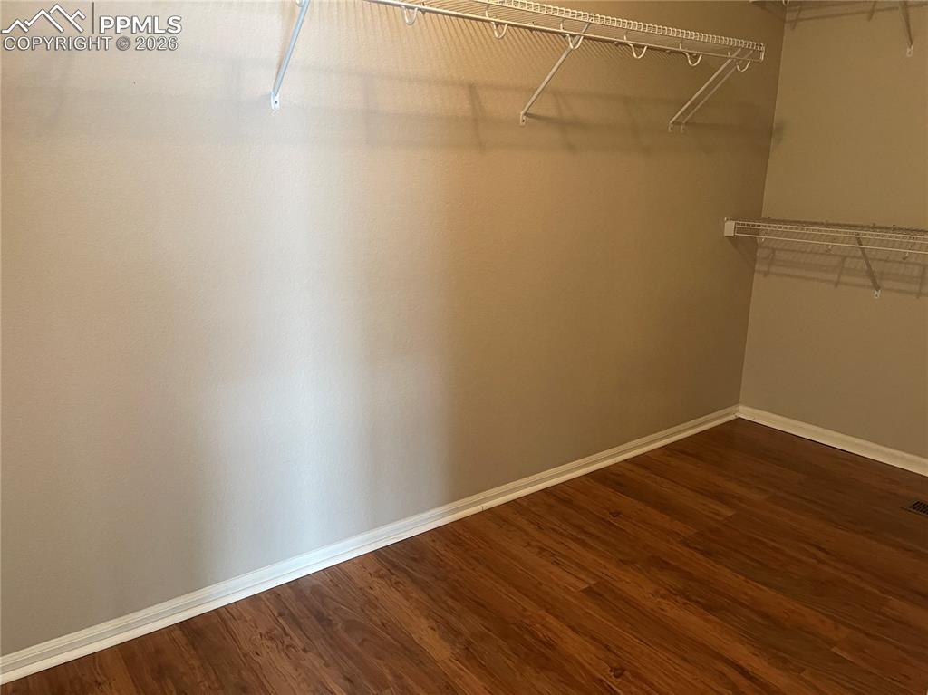 Image 11 of 15: Interior storage space featuring wood-finish flooring, light tan walls, whi