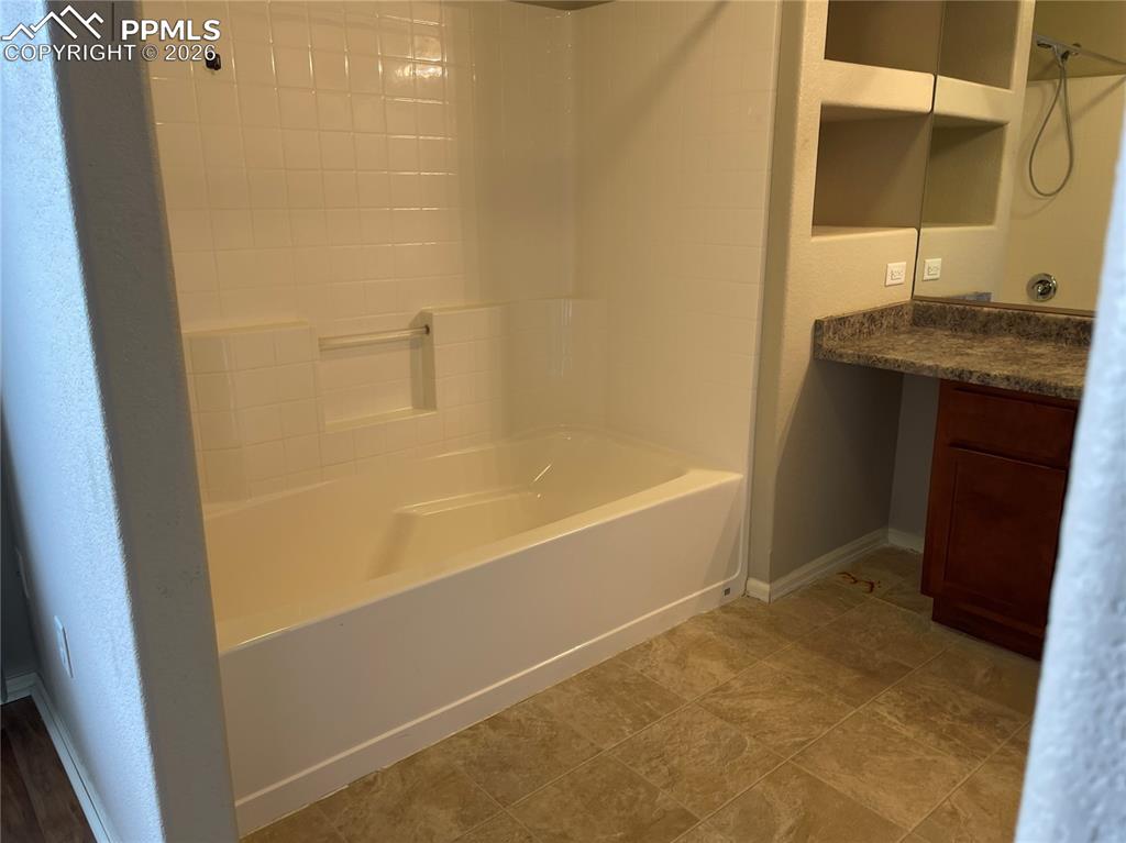 Image 14 of 15: Bathroom featuring a white subway tile tub surround, integrated bathtub, a 