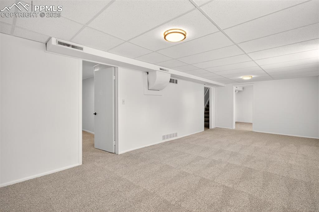 Image 12 of 17: Newly carpeted basement family room. area with stairway, and newly installe