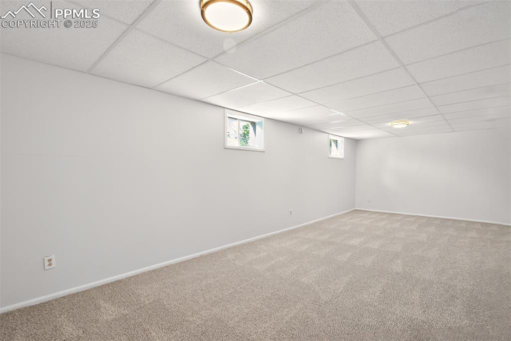 Image 14 of 17: Basement with carpet floors and a drop ceiling