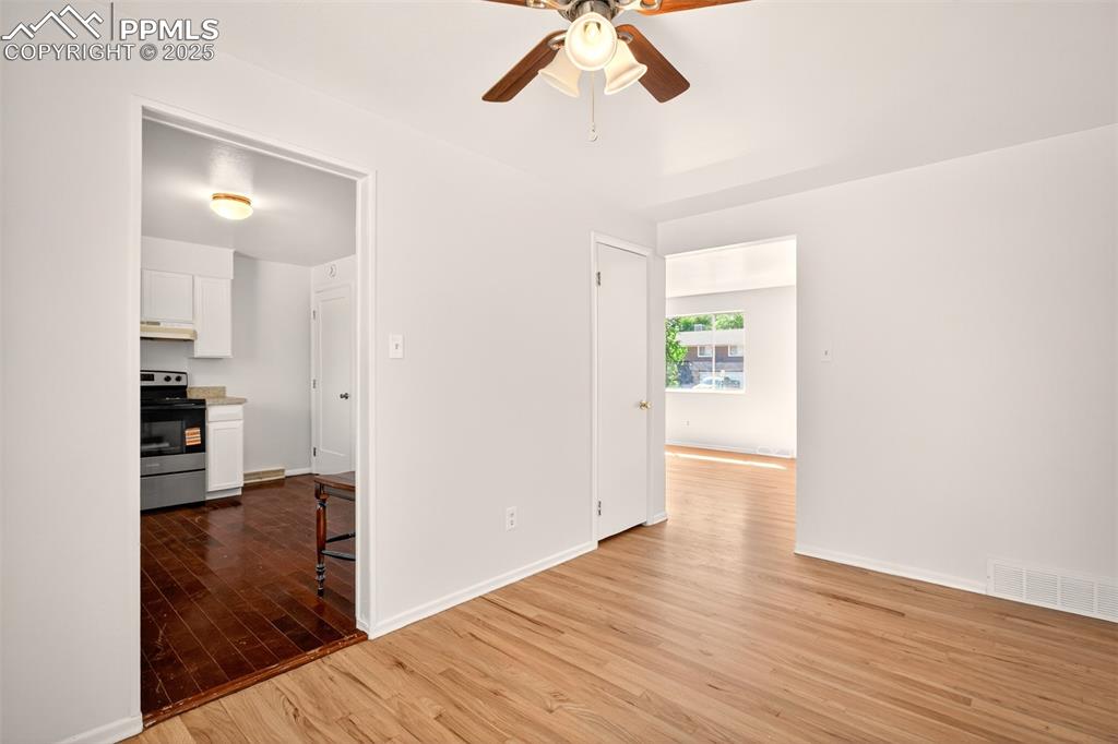 Image 6 of 17: Dining are off of living room with light wood-style flooring and ceiling f