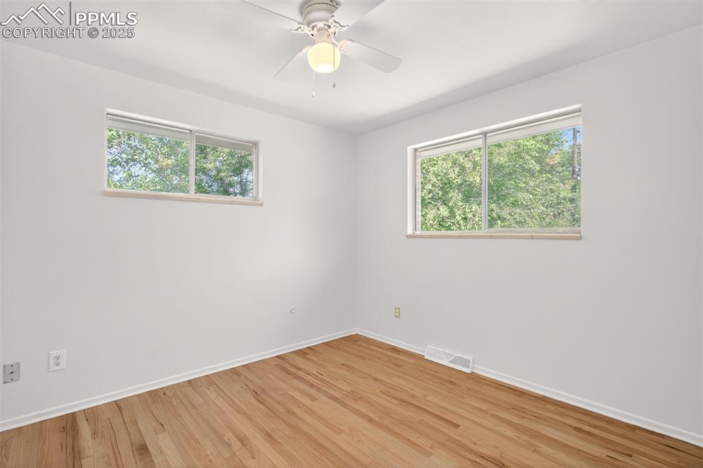 Image 9 of 17: Bedroom with light wood-style flooring and a ceiling fan