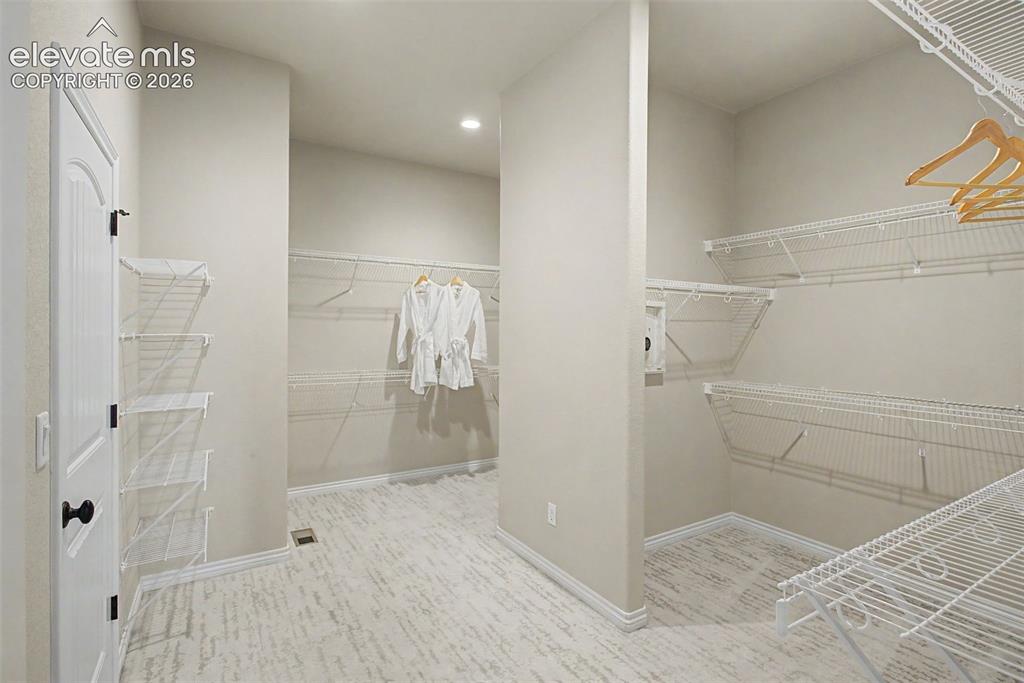 Image 24 of 50: His and her sides of the huge primary closet