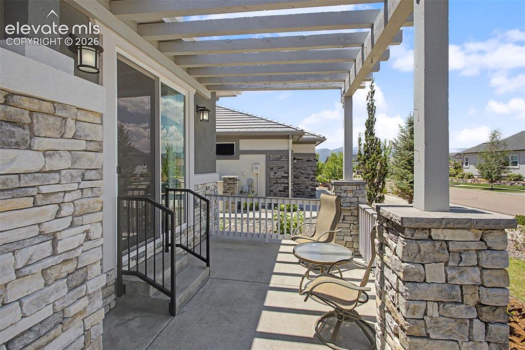 Image 26 of 50: Front porch with custom pergola that connects to the Next-Gen suite