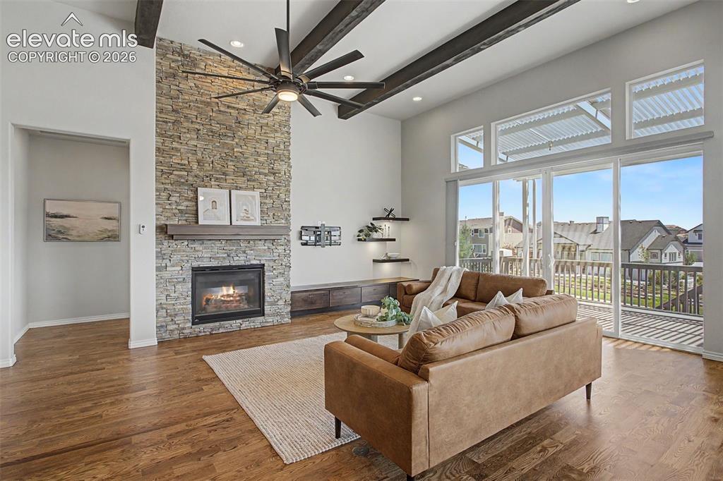 Image 7 of 50: Cathedral beamed ceilings and rocked fireplace highlight the space
