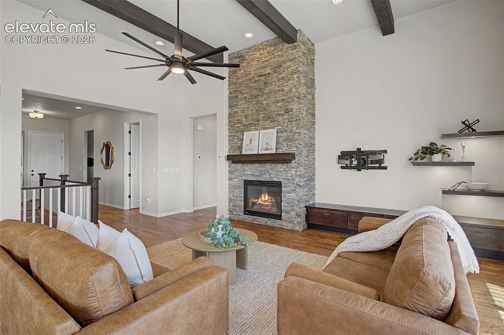 Image 8 of 50: Cathedral beamed ceilings and rocked fireplace highlight the space