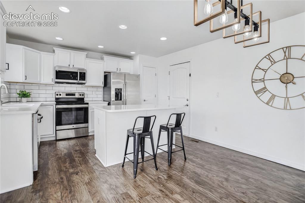 Image 5 of 20: Kitchen w/ island featuring barstool seating