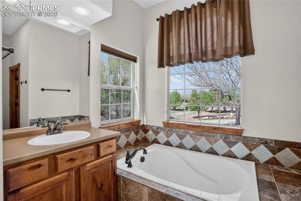 Image 13 of 33: Separate vanities and soaking tub