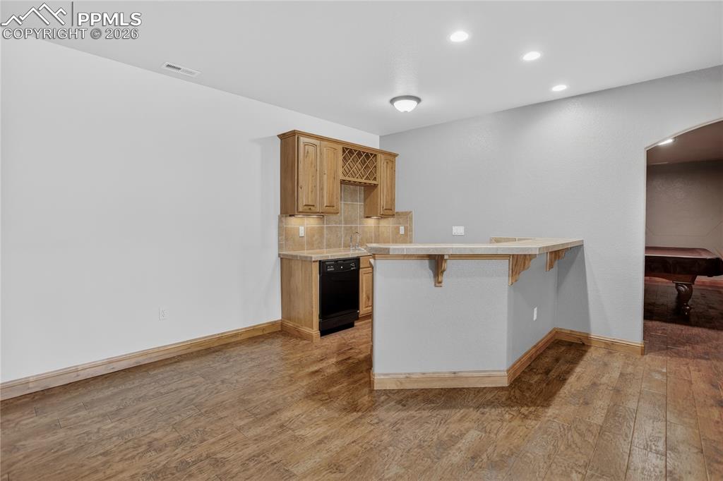 Image 21 of 33: Wet bar w/ barstool seating